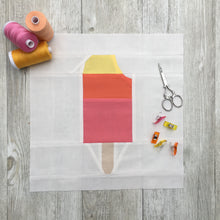 Load image into Gallery viewer, Popsicle 2 quilt block pattern by Penny Spool Quilts. Part of the Ice Cream Sunday collection. Tri-coloured popsicle with a bite taken out in top right corner, in yellow, orange and pink solid fabrics on white background. shown with spools of thread, clips and scissors