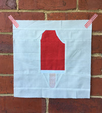 Load image into Gallery viewer, Ice Cream Bar 2 foundation paper pieced quilt block pattern by Penny Spool Quilts. Shows red creamsicle bar with bite out of top corner, on white background fabric.