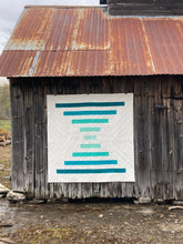 Load image into Gallery viewer, Raise the Bar quilt pattern by Penny Spool Quilts - Sample quilt in turquoise ombre and white on old barn wall