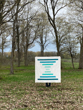 Load image into Gallery viewer, Raise the Bar quilt pattern by Penny Spool Quilts - Sample quilt in turquoise ombre and white held up in the forest
