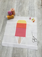 Load image into Gallery viewer, Popsicle 1 quilt block pattern by Penny Spool Quilts. Part of the Ice Cream Sunday collection. Tri-coloured popsicle in yellow, orange and pink solid fabrics on white background. shown with spools of thread, clips and scissors
