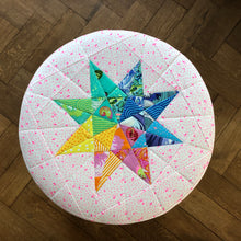 Load image into Gallery viewer, Rainbow Star Quilt Block Pattern by Penny Spool Quilts. Eight pointed star made using a rainbow of Tula Pink fabrics and used as a cover for office stool.

