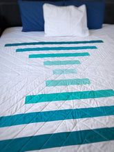 Load image into Gallery viewer, Raise the Bar quilt pattern by Penny Spool Quilts - Sample quilt in turquoise ombre and white on a bed
